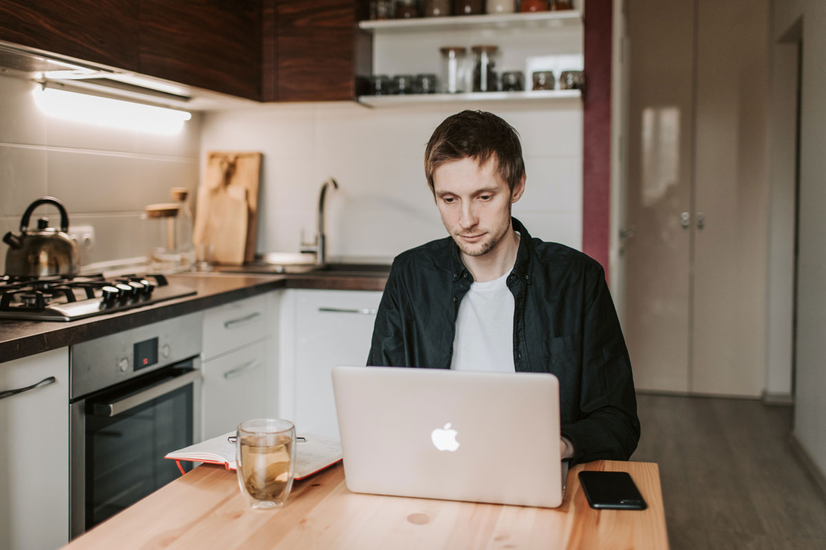 Man working from Laptop in home kitchen