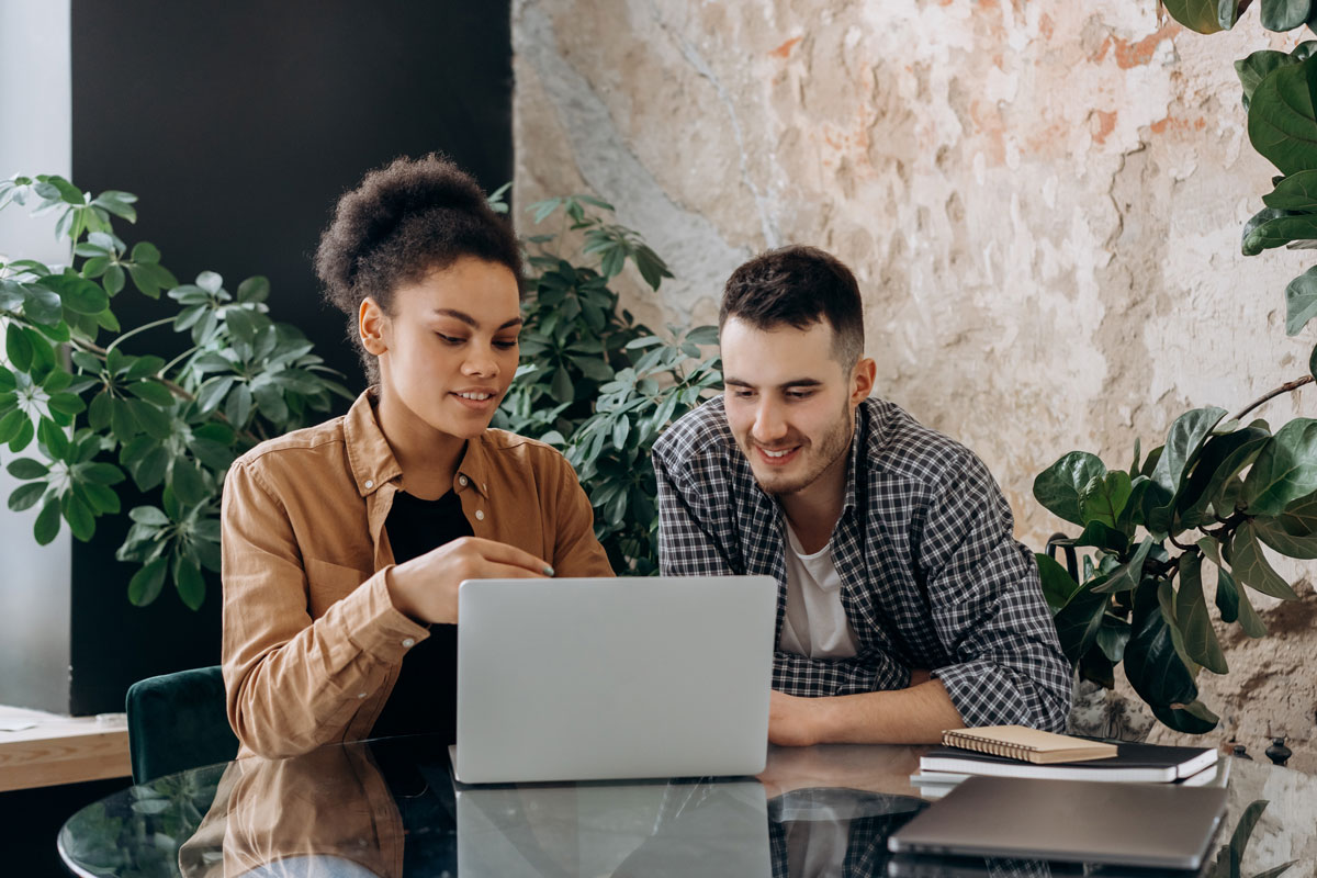 Couple sitting at computer looking pleased